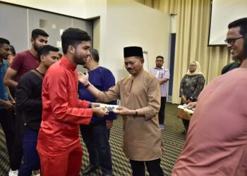 NUR AZMI Ahmad menyampaikan sumbangan duit raya pada Majlis Berbuka Puasa Melaka FC di sebuah hotel di Melaka.