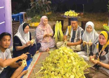 SAHARUDDIN KAMIJAN  (tiga dari kanan) dan ahli keluarganya menganyam ketupat bagi memenuhi permintaan pelanggan sempena Hari Raya Aidilfitri di rumahnya di Kampung Parit Serong, Sanglang, Pontian.