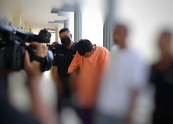 TERTUDUH (tengah) dibawa untuk menghadiri perbicaraan di Mahkamah Sesyen Pasir Mas, Kelantan hari ini-UTUSAN/KAMARUL BISMI KAMARUZAMAN