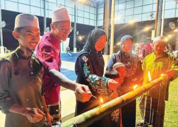 NOORZILAWATI Ab. Rahim (dua dari kanan) melihat pelita buluh yang dipasang di Kampung Limau Kasturi, Gua Musang, Kelantan. – UTUSAN/AIMUNI TUAN LAH