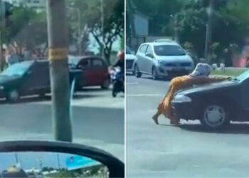 TANGKAP layar video tular menunjukkan seorang wanita cuba menahan sebuah kereta yang bergerak di persimpangan jalan lampu isyarat di Port Dickson.