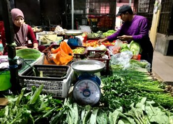 SEORANG pelanggan (kanan) memilih sayur-sayuran yang dijual di Pasar Siti Khadijah, Kota Bharu, Kelantan. - UTUSAN/ROSLIZA MOHAMED