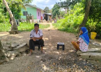 MAT Yusof Kasim bersama isteri terpaksa berehat di halaman rumah  ekoran cuaca panas di Kampung Banggol Che Wan, Meranti, Pasir Mas, Kelantan. - UTUSAN/ROHANA ISMAIL