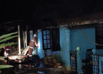 ANGGOTA bomba mengawal kebakaran sebuah rumah dalam kejadian di Kampung Tanjung, Gadong, Rembau malam tadi.-UTUSAN/NOR AINNA HAMZAH.