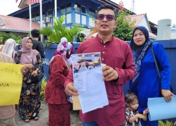ARZA Zahari menunjukkan risalah pakej umrah yang didakwa satu penipuan beserta salinan laporan yang dibuat di Balai Polis Kota Bharu, Kelantan hari ini- UTUSAN/MUSTAQIM MOHAMED