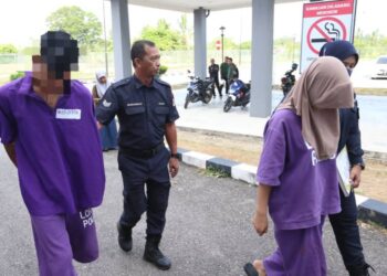 PASANGAN suami isteri diiringi oleh polis semasa hadir untuk mendapatkan perintah reman di Mahkamah Majistret Kota Bharu, Kelantan hari ini-UTUSAN/KAMARUL BISMI KAMARUZAMAN