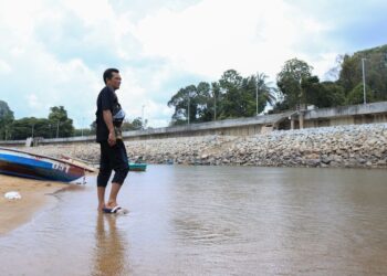 SEORANG penduduk berjalan kaki sambil meninjau keadaan air yang kering dan cetek di Sungai Golok, Rantau Panjang, Kelantan semalam. – UTUSAN/KAMARUL BISMI KAMARULZAMAN