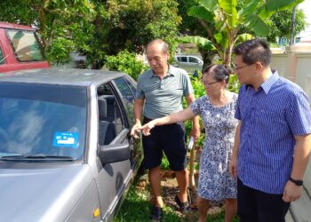 GUE Boon Guan (kiri) dan Gan Chui Lan (tengah) menunjukkan kepada Lim Ban Hong keadaan cermin kereta mereka yang dipecahkan dua penyamun dalam kejadian di Taman Megah, Klebang, Melaka. - UTUSAN/AMRAN MULUP