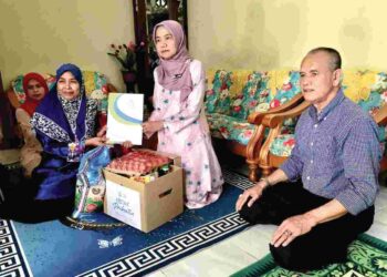 NORA Yaacob (dua, kanan) menyampaikan sumbangan Faedah Pengurusan Mayat kepada Kasmara Kadir (kiri) di Kampung Pulau Melaka, Kota Bharu, Kelantan, semalam. – UTUSAN/ ROSLIZA MOHAMED
