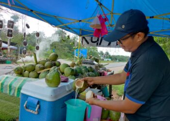 MOHD. Ghazali Esa menyediakan air kelapa pandan untuk dibungkus dan dijual kepada pelanggan yang datang ke gerainya di Jalan Kota Tinggi - Kluang berhampiran Bulatan Mardi di Kluang.