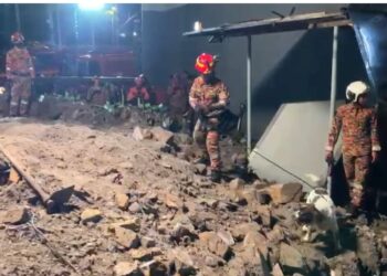ANJING pengesan melakukan pencarian mangsa dipercayai pengawal keselamatan tertimbus dalam runtuhan tebing berhampiran Wisma YPR, Taman Seputeh tengah malam tadi. Mangsa ditemukan pada 6.23 pagi hari ini.-IHSAN BOMBA