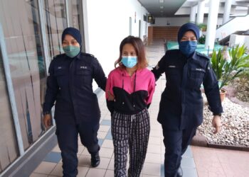 TERTUDUH diiring keluar anggota polis selepas dihadapkan ke Mahkamah Majistret, Ayer Keroh, Melaka atas dua pertuduhan menyerang dan menghalang seorang pegawai polis. - UTUSAN/MUHAMMAD SHAHIZAM TAZALI