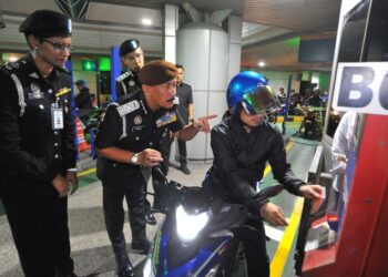 RUSLIN Jusoh (dua dari kiri) melihat proses pengimbasan pasport dan cap jari penunggang motosikal  di kaunter  M Bike  ketika melakukan lawatan di Bangunan Sultan Iskandar, Johor Bahru disini. UTUSAN/RAJA JAAFAR ALI