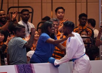 Sureeya memeluk ibu sambil disaksikan oleh bapanya yang hadir menyaksikan perlawanannya di Pusat Konvensyen Chroy Changvar, Phnom Penh semalam.-UTUSAN/AMIR KHALID