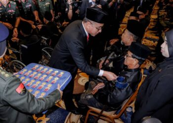 ADLY Zahari (kiri) memakaikan PJM kepada salah seorang veteran Angkatan Tentera Malaysia (ATM) pada Majlis Penganugerahan PJM di MITC, Ayer Keroh, Melaka. - UTUSAN/SYAFEEQ AHMAD