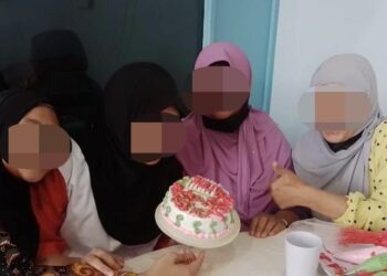 YAYA (dua kiri) yang merupakan banduan akhir menghias kek bersama ibu dan adiknya dalam majlis Jalinan Kasih sempena Aidilfitri di Penjara Wanita Kota Kinabalu baru-baru ini.