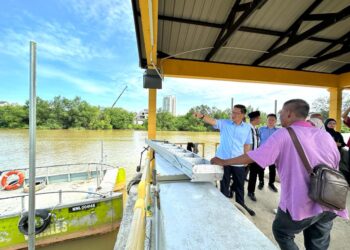 LIM Ban Hong (kiri) menunjukkan sesuatu kepada nelayan ketika melakukan lawatan di Jeti Nelayan Klebang Besar, Melaka. - UTUSAN/AMRAN MULUP