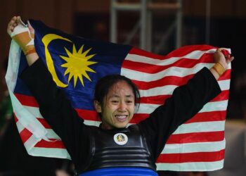 Nor Farah Mazlan mengibarkan bendera Malaysia selepas merangkul emas di Sukan SEA Kemboja.-UTUSAN/AMIR KHALID