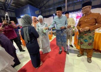 MUHAMAD Zaki Harun (dua dari kanan) menyampaikan duit raya kepada anak-anak anggota polis di majlis sambutan Hari Raya Aidilfitri peringkat Ibu Pejabat Polis Daerah (IPD) Pasir Puteh, Kelantan, semalam. UTUSAN/TOREK SULONG