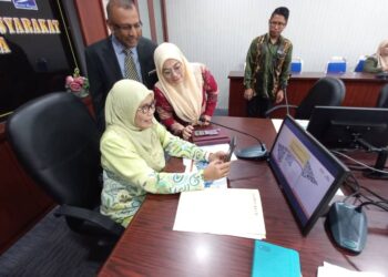 KALSOM Noordin mengimbas kod QR Prih@tinJkmMelaka selepas melancarkannya di Pejabat JKM Melaka, Kota Cemerlang, Ayer Keroh, Melaka. - UTUSAN/AMRAN MULUP