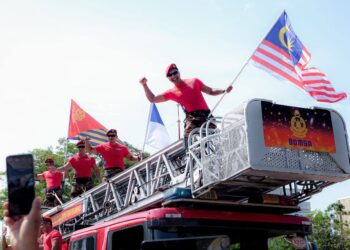 GENG abang sado JBPM mengibarkan Jalur Gemilang, bendera negeri Melaka dan bendera JBPM sempena Sambutan Hari Anggota Bomba Sedunia 2023 sambil diperhatikan Nga Kor Ming (kiri) di Dataran Memorial Pengisytiharan Kemerdekaan, Banda Hilir, Melaka. - UTUSAN/SYAFEEQ AHMAD