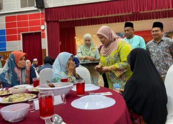 RUBIAH Wang (berdiri, kanan) menyampaikan sumbangan kepada penerima asnaf di Dewan Datuk Ariffin Said, Ibu Pejabat Kesedar Gua Musang, Kelantan hari ini.-UTUSAN/AIMUNI TUAN LAH