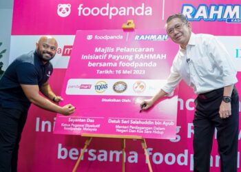 SALAHUDDIN Ayub (kanan) bersama Sayantan Das melakukan gimik pelancaran Inisiatif Payung RAHMAH bersama Foodpanda Malaysia di Pejabat Foodpanda. - UTUSAN/FARIZ RUSADIO