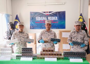 ISKANDAR Ishak (tengah) menunjukkan rokok keretek yang dirampas dalam sidang akhbar di Pejabat Maritim Melaka dan Negeri Sembilan di Kuala Linggi, Melaka. - UTUSAN/MUHAMMAD SHAHIZAM TAZALI