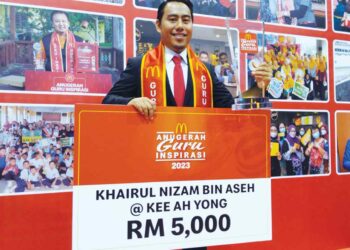KHAIRUL 
NIZAM Aseh bersama trofi dan replika cek pada Majlis Anugerah Guru Inspirasi 2023 di MITC, Ayer Keroh, Melaka.  
– UTUSAN/MUHAMMAD SHAHIZAM TAZALI