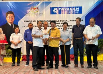 EWON Benedick menyerahkan bantuan persekolahan yang diperuntukkan YBR kepada wakil sekolah dalam satu majlis di Dewan SM St. Michael, Penampang, Sabah. - IHSAN YBR