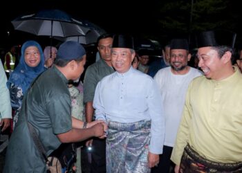 MUHYIDDIN Yassin bersalaman dengan orang ramai sambil diiringi Mohd. Yadzil Yaakub (kanan) ketika Rumah Terbuka Aidilfitri PN Melaka di pekarangan Pusat Khidmat Masyarakat DUN Bemban, Jasin, Melaka. - UTUSAN/SYAFEEQ AHMAD