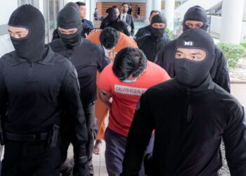 KEDUA-DUA tertuduh diiring keluar anggota polis selepas dihadapkan ke Mahkamah Majistret, Ayer Keroh, Melaka atas pertuduhan membunuh seorang pengurus syarikat. - UTUSAN/SYAFEEQ AHMAD
