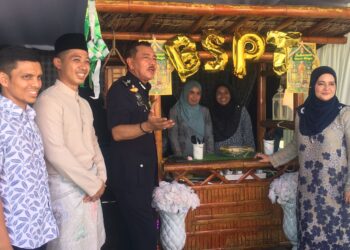 MUHAMAD Zaki Harun (tiga dari kiri) mengambil peluang untuk bergambar di gerai juadah hari raya pada Majlis Sambutan Aidilfitri di Ibu Pejabat Polis Daerah (IPD) Tanah Merah, Kelantan hari ini. UTUSAN/ ROSMIZAN RESDI