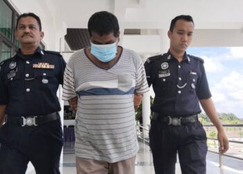 TERTUDUH diiring anggota polis selepas dihadapkan ke Mahkamah Majistret, Alor Gajah, Melaka atas enam pertuduhan penipuan. - UTUSAN/MUHAMMAD SHAHIZAM TAZALI