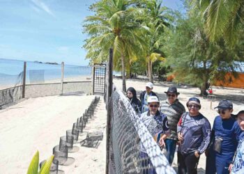 TUN Ahmad Faisal Tun Abdul Razak (tiga, kiri) meninjau pusat penetasan telur penyu ketika melawat Pusat Taman Laut di Pulau Redang, Kuala Nerus, semalam. -  UTUSAN/PUQTRA HAIRRY ROSLI