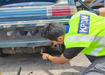 ANGGOTA penguat kuasa KPDN Kelantan menunjukkan tangki tambahan yang terdapat pada sebuah kereta milik penyeludup semasa melakukan operasi di Tumpat, Kelantan. - IHSAN KPDN KELANTAN