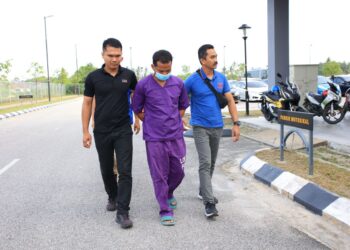 TERTUDUH di iringi oleh anggota polis semasa hadir untuk pertuduhan di Mahkamah Sesyen Kota Bharu, Kelantan.UTUSAN/KAMARUL BISMI KAMARUZAMAN