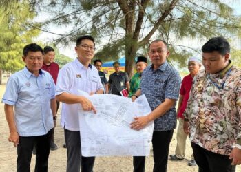 LIM Ban Hong (dua dari kiri) dan Shadan Othman (dua dari kanan) menunjukkan pelan pembangunan Klebang Walk di Pantai Klebang, Melaka.