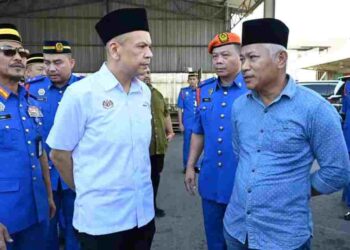 ARMIZAN Mohd. Ali (dua kiri) tenangkan abang Allahyarham Awang Askandar, Awang Asim Ampuan Yaacub (kanan) di pekarangan MAS Kargo, di Kota Kinabalu hari ini