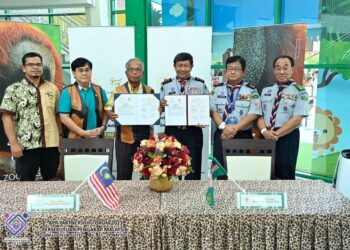 MOHD. Zin Bidin (tengah) dan  Zaharin Md. Arif menunjukkan  MoU yang ditandangani di  Rotunda Hall, Zoo Negara, Hulu Kelang, kelmarin.