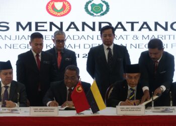MUHAMMAD Sanusi Md. Nor (duduk, tengah) bersama Mohd. Shukri Ramli (duduk, kanan) menandatangani dokumen bagi memuktamadkan perjanjian sempadan darat dan maritim Kedah dan Perlis di Wisma Darul Aman, Alor Setar.