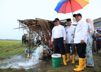 MOHAMAD Sabu (kiri) semasa meninjau pam air yang disediakan kerajaan untuk kemudahan petani di Kampung Bukit Kechik, Gunung, Bachok, Kelantan-UTUSAN/KAMARUL BISMI KAMARUZAMAN