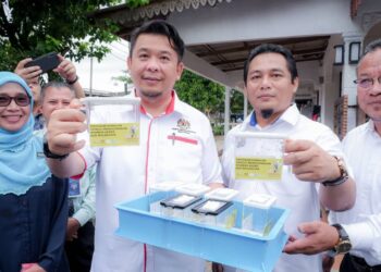 LUKANISMAN Awang Sauni (dua dari kiri) menunjukkan nyamuk berbakteria Wolbachia pada program pelepasan di Taman Bemban Jaya, Jasin, Melaka. - UTUSAN/SYAFEEQ AHMAD