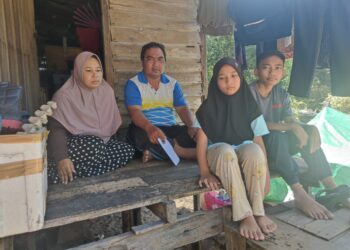 MUHAMMAD Ridhuan Abdullah (dua kiri)  bersama isterinya, Hasnah Haron dan dua orang anak di rumah mereka di Kampung Pengkalan Ubi Keling, Kuala Besut, Besut, Terengganu. - UTUSAN/ZAID MOHD. NOOR