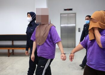TERDUDUH (dua dari kanan) diringi polis semasa hadir untuk mendapatkan perintah reman di Mahkamah Majistret Kota Bharu, Kelantan-UTUSAN/KAMARUL BISMI KAMARULZAMAN