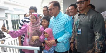 ANWAR Ibrahim bergambar besama penduduk pada majlis penyerahan kunci Perumahan Penjawat Awam Malaysia (PPAM) Dalur Madani di Putrajaya. - UTUSAN/FAISOL MUSTAFA