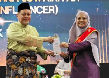 MOHD. Amar Nik Abdullah (kiri) menyampaikan Anugerah Juwairiyah Al-Harith kepada bekas Ahli Dewan Negara, Asmak Husin pada Majlis Pelancaran Hari Sayyidatina Khadijah di PUTIK Pengkalan Chepa, Kota Bharu, Kelantan hari ini. UTUSAN/MUSTAQIM MOHAMED