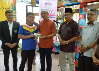 FAIROL NIZAM Roslan (tiga dari kiri) menyampaikan sumbangan kepada salah seorang atlet angkat berat yang menyumbang emas di Kemas Selandar, Alor Gajah, Melaka. - UTUSAN/AMRAN MULUP