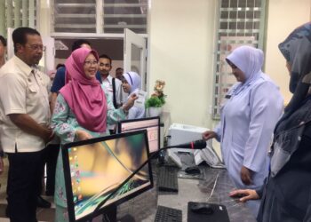 ZALIHA Mustafa (dua dari kiri ) beramah mesra dengan petugas KKM di kaunter pertanyaan Klinik Kesihatan Mata Ayer,Machang, Kelantan hari ini. UTUSAN/ROSMIZAN RESDI