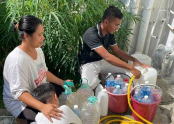 PENDUDUK bergilir-gilir mengisi air menggunakan gelen dan botol mineral untuk dibawa ke tingkat atas di Pangsapuri Melinsung Summer Bay Resort di Papar hari ini